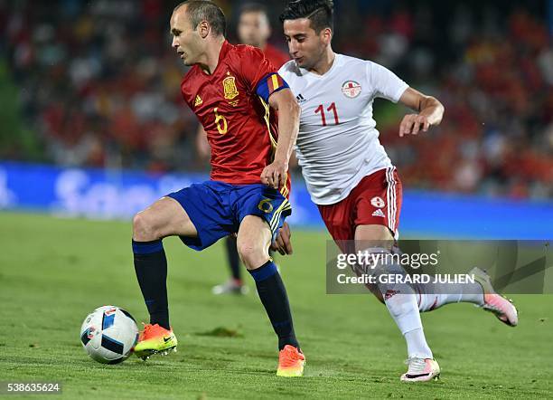 Georgia's forward Giorgi Chanturia vies for the ball with Spain's midfielder Andres Iniesta during the EURO 2016 friendly football match Spain vs...