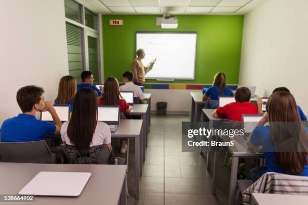 back view of students attending a class in computer lab. - computer training stock pictures, royalty-free photos & images