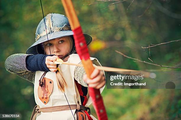 niña pequeña arquero apuntando - bow and arrow fotografías e imágenes de stock