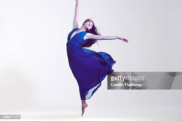 portrait of woman jumping - blue dress fotografías e imágenes de stock