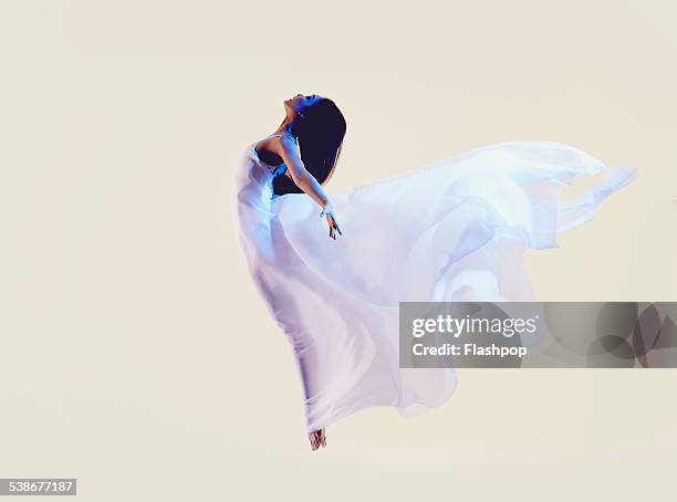 portrait of woman jumping - evening gown photos et images de collection