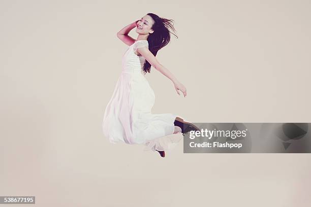 portrait of woman jumping - weißes kleid stock-fotos und bilder
