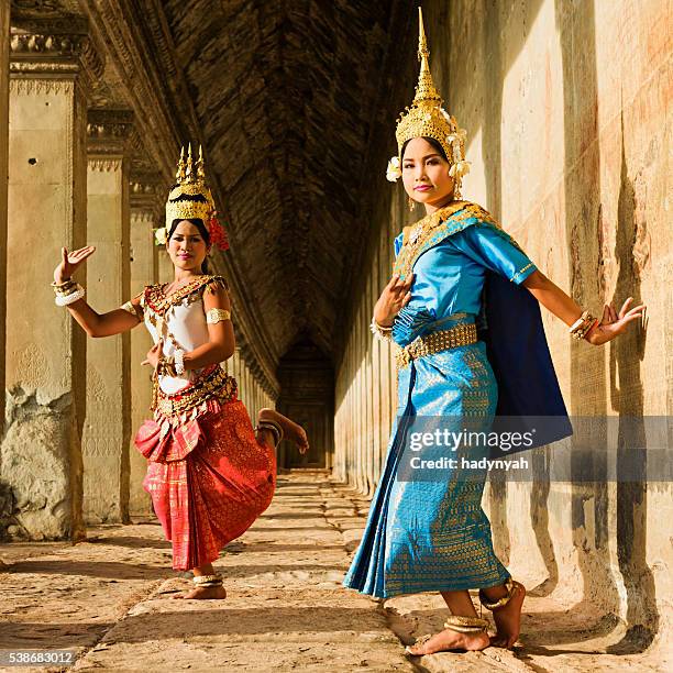 apsara dancers posing in angkor wat, cambodia - apsara stockfoto's en -beelden