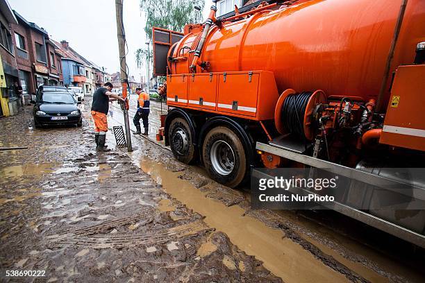 People are cleaning up mud after they got struck by floods caused by heavy rainfall in Rillaar, Flemish Brabant, Belgium on June 7, 2016.
