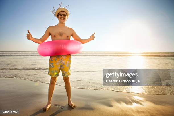 touristen am strand - schwimmring stock-fotos und bilder