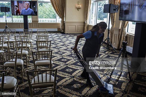 Worker vacuums a carpet before Donald Trump, presumptive Republican presidential nominee, not pictured, speaks during a primary night event at the...