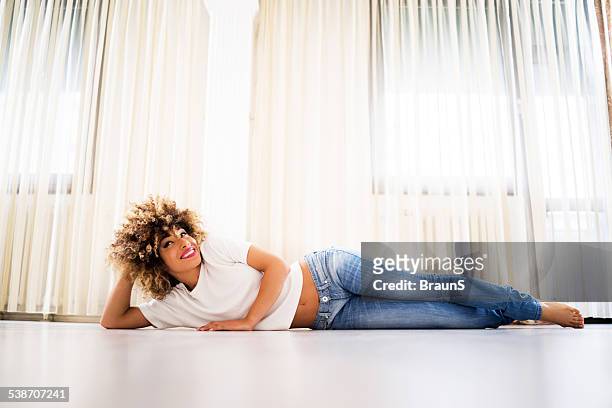 happy african american woman. - lying on side stockfoto's en -beelden