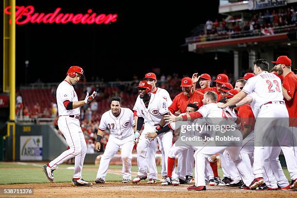 Joey Votto of the Cincinnati Reds celebrates with teammates after hitting the game-winning home run against the St. Louis Cardinals in the ninth...