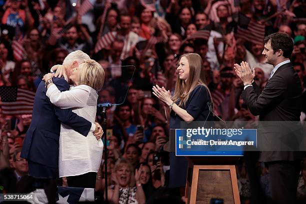 Husband and former president Bill Clinton hugs Democratic presidential candidate Hillary Clinton as daughter Chelsea Clinton and Marc Mezvinsky look...