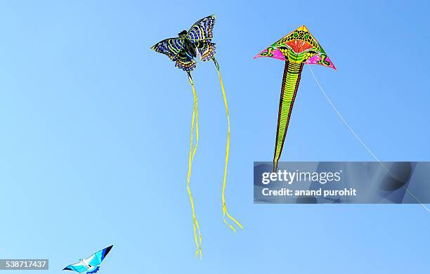 colourful kites flying in clear blue sky, india - pongal stock pictures, royalty-free photos & images