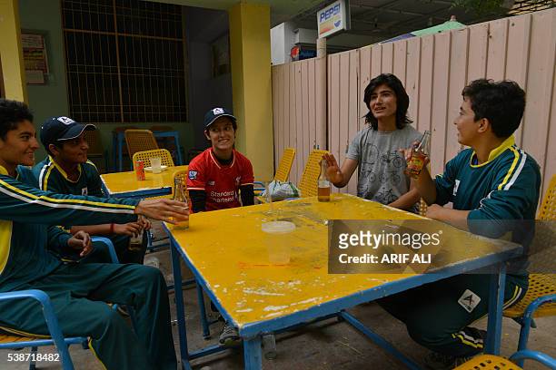 In this photograph taken on May 3 Pakistani national cricket and football player Diana Baig shares a light moment with her colleagues at a football...