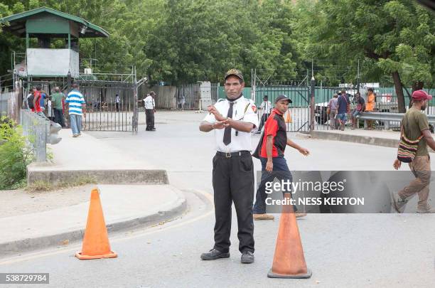 Security officer blocks the main entrance of a major supermarket in Port Moresby following a protest rally by the students in Port Moresby on June 8,...