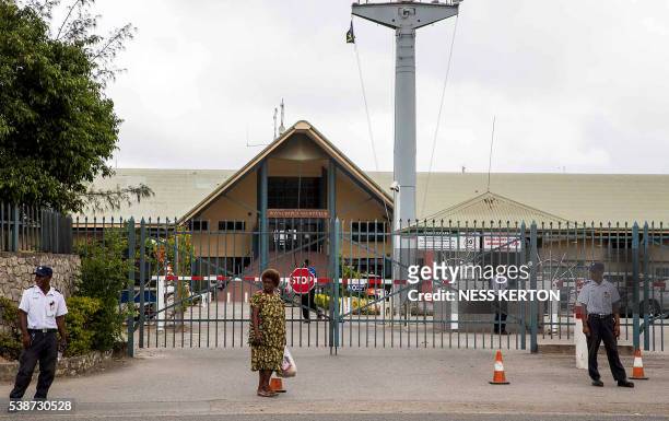 Security officers stand guard in front of the closed gate of the Royal Papua Yacht Club following a protest rally by the students in Port Moresby on...