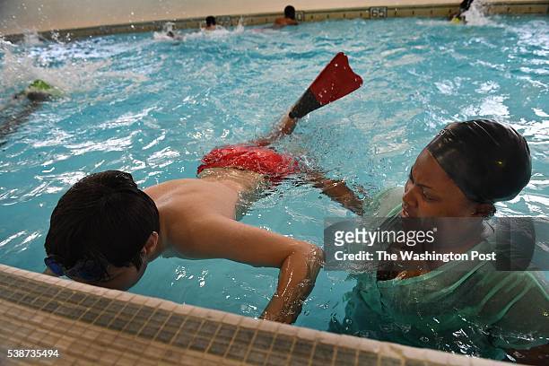 Instructor aide Alexis Brittingham helps steady Aiden Torgovitsky at a water safety class for autistic students at the Cardozo Education Campus in...