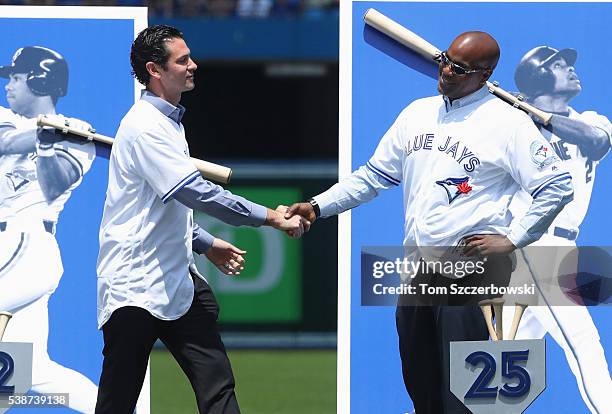 Former player Shawn Green of the Toronto Blue Jays is greeted by former teammate Carlos Delgado as he is introduced during 40th anniversary...