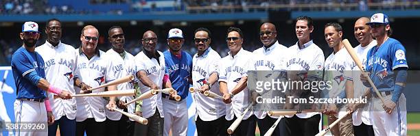 Jose Bautista of the Toronto Blue Jays poses beside former players John Mayberry and Ernie Whitt and Tony Fernandez and Lloyd Moseby and current...