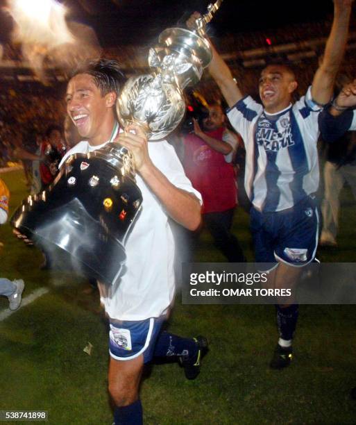 Soccer player Alberto Rodriguez runs with the victory trophy folloowed by his teammates 15 December 2001 in Monterrey, Mexico. Alberto Rodriguez ,...