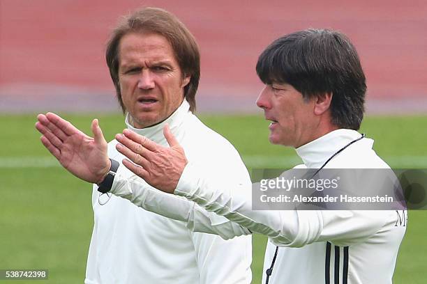Joachim Loew, head coach of the German national team talks to his assistant coach Thomas Schneider during a Germany training session ahead of the...