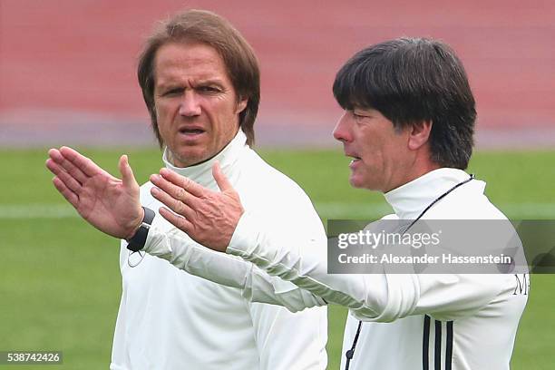 Joachim Loew, head coach of the German national team talks to his assistant coach Thomas Schneider during a Germany training session ahead of the...