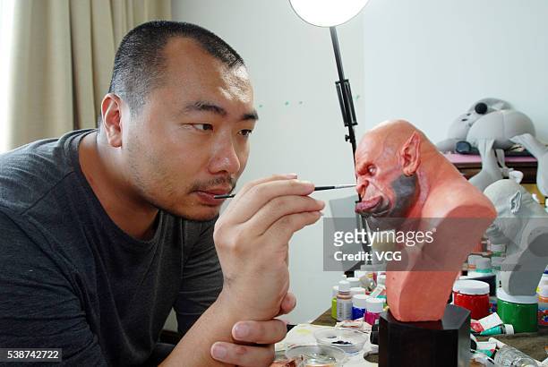 Artist Yan Chuan paints his figurine creation of Garrosh Hellscream from World of Warcraft on June 8, 2016 in Shenyang, China. Chuan is a fan of...