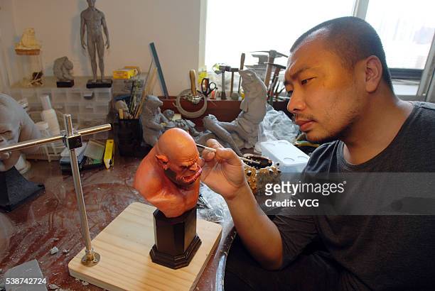 Artist Yan Chuan paints his figurine creation of Garrosh Hellscream from World of Warcraft on June 8, 2016 in Shenyang, China. Chuan is a fan of...