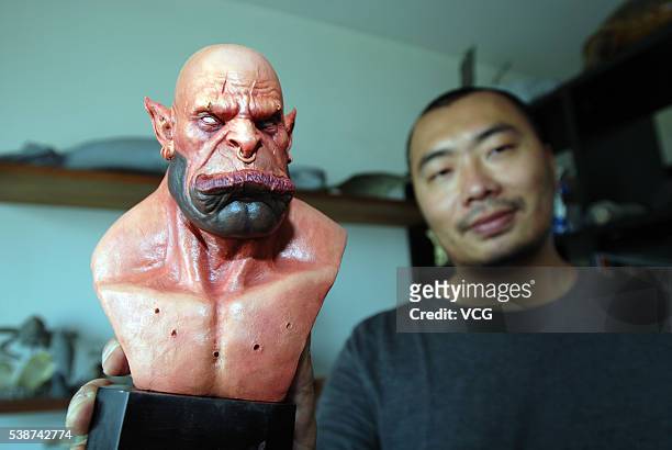 Artist Yan Chuan holds up his figurine creation of Garrosh Hellscream from World of Warcraft on June 8, 2016 in Shenyang, China. Chuan is a fan of...