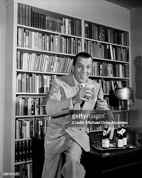 Ed Sullivan host of "Toast of the Town" drinks some ginger ale in his office at the Maxine Elliott Theater in New York, New York.