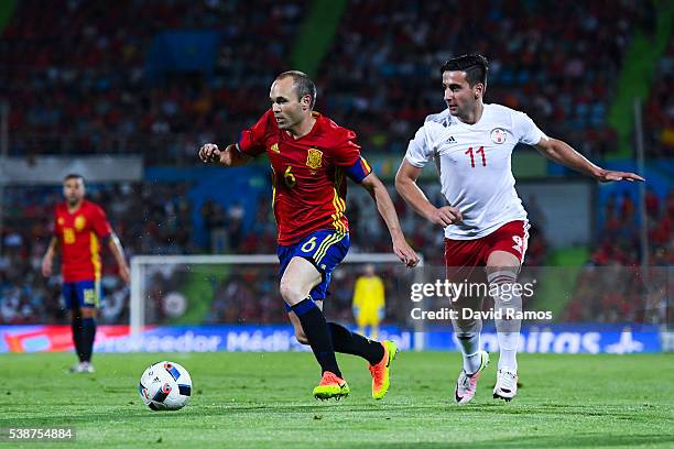 Andres Iniesta of Spain competes for the ball with Chanturia of Georgia during an international friendly match between Spain and Georgia at Alfonso...