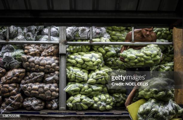 Workers help each other carry vegetables in Divisoria Market in Manila on June 8, 2016. The Philippines' economy grew a better-than-expected 6.9...