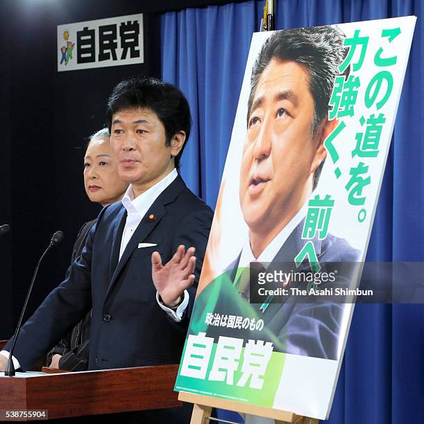 Ruling Liberal Democratic Party public relations chief Taro Kimura unveils the election campaign poster at the LDP headquarters on June 8, 2016 in...