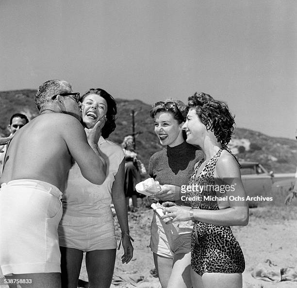 Actress Elaine Stewart looks on as Adelle August is kissed during the Thalians Beach Ball in Malibu,California.