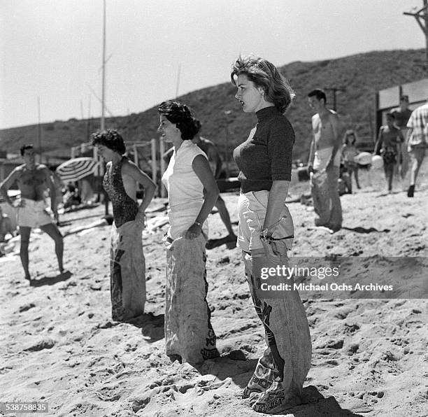 Actress Elaine Stewart and Adelle August get ready for a sack race during the Thalians Beach Ball in Malibu,California.