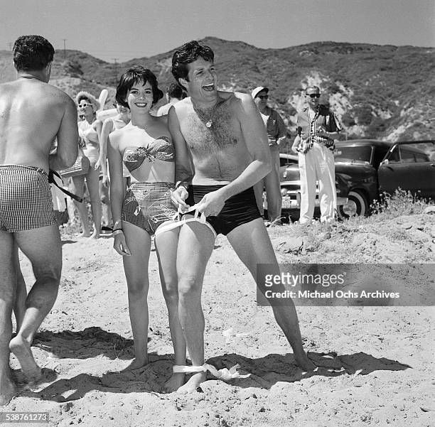 Actress Natalie Wood and actor Hugh O'Brian enter the one legged race during the Thalians Beach Ball in Malibu,California.