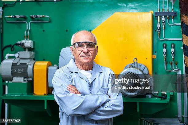 portrait of senior worker in factory - working seniors stock pictures, royalty-free photos & images