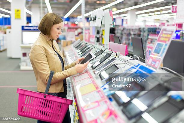 woman buys a digital tablet - consumer electronics industry stock pictures, royalty-free photos & images