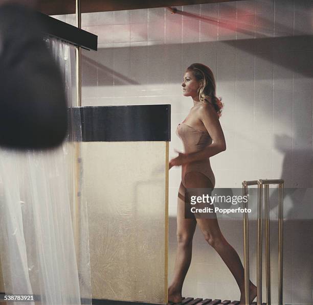 Swiss born actress Ursula Andress pictured in character as Honey Ryder wearing a flesh coloured leotard in a shower scene from the James Bond film...