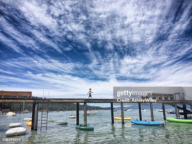 menino andando em uma doca em lago tahoe no verão - lago tahoe - fotografias e filmes do acervo