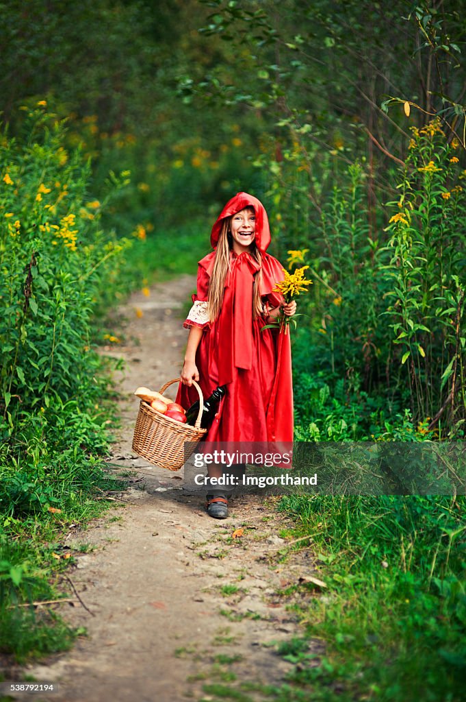 Happy Little Red Riding Hood in den Wald zu Fuß