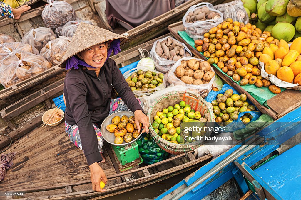 Woman selling fruits on floating market, Mekong River Delta,