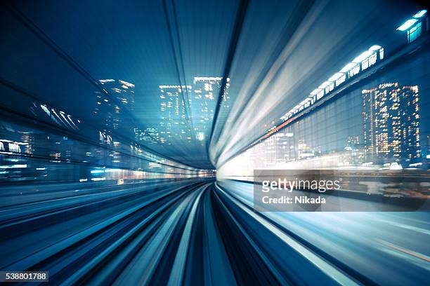 bewegungsunschärfe der zug in bewegung zu stadt - high speed train stock-fotos und bilder