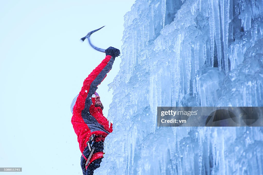 - Kletterer aufsteigender einem gefrorenen Wasserfall