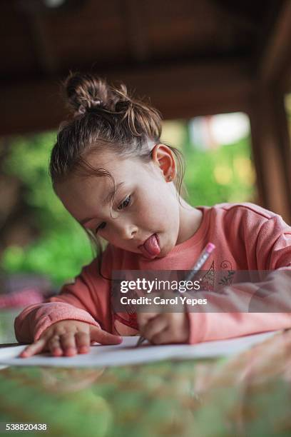 little girl doing her homework - blonde girl sticking out her tongue stock pictures, royalty-free photos & images