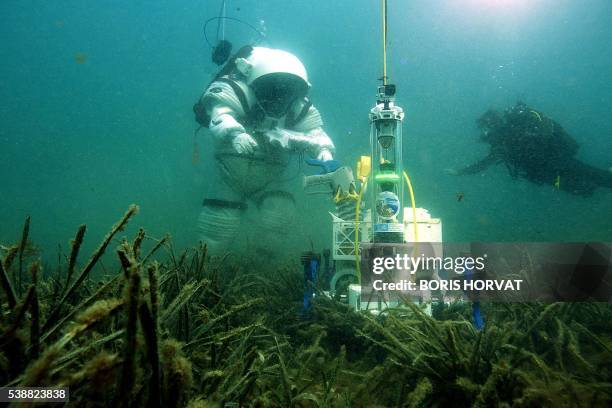 Comex diver wearing a Gandolfi space suit walks underwater during a "Moonwalk" operation in the Mediterranean sea at the Frioul islands near...