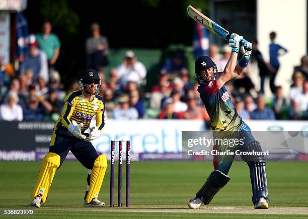 Joe Denly of Kent hits out while wicket keeper Adam Wheater of Hampshire looks on during the NatWest T20 Blast match between Kent and Hampshire at...