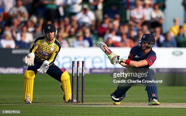 Sam Billings of Kent hits out while Hampshire wicket keeper Adam Wheater looks on during the NatWest T20 Blast match between Kent and Hampshire at...