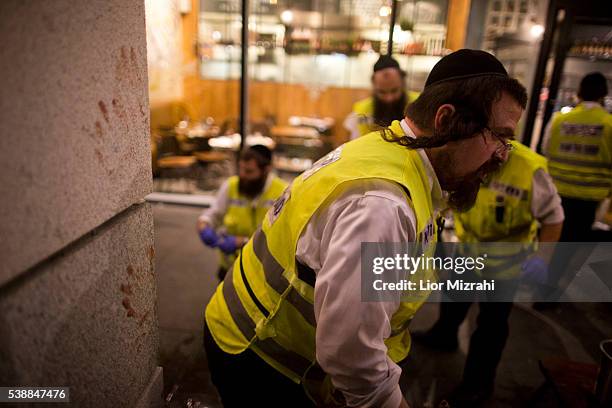 Members of an Israeli ZAKA - Identification, Extraction and Rescue team work at the scene of a shooting outside Max Brenner restaurant in Sarona...