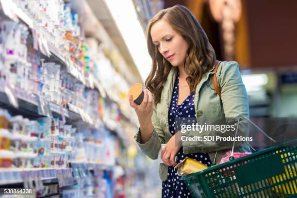 woman reading food labels at grocery store - ingredient stock pictures, royalty-free photos & images