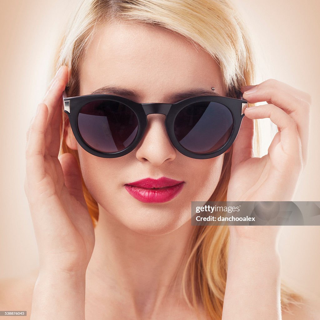 Beautiful blonde woman wearing sun glasses close up shot