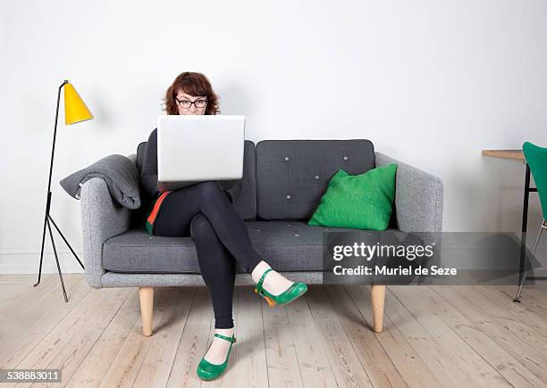 woman with computer, home - couch weiße wand stock-fotos und bilder