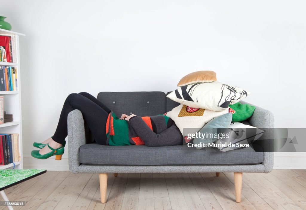 Woman hidden by pillows